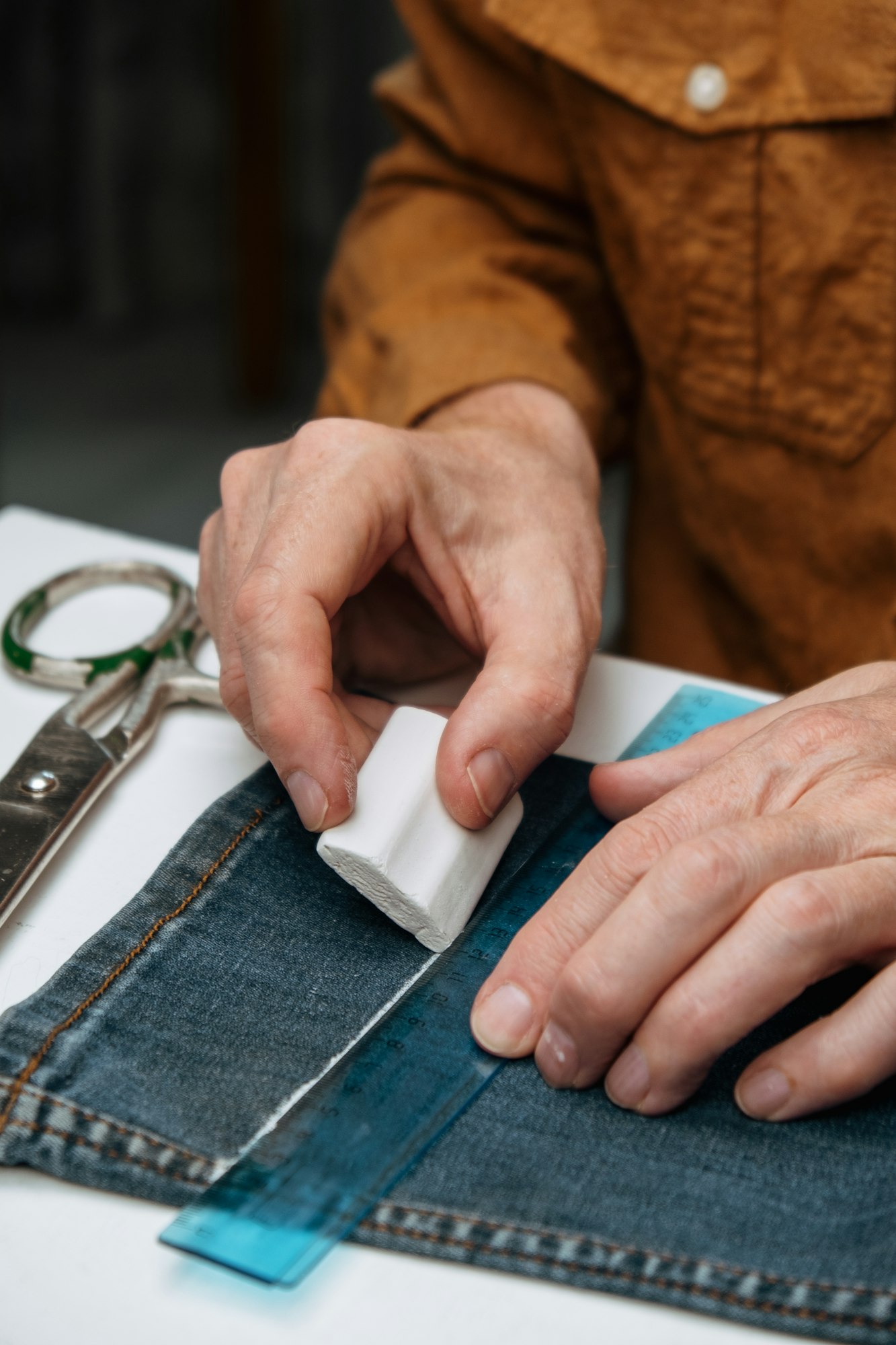 tailor in a sewing studio works with jeans. alteration, hemming, shortening or upgrade.